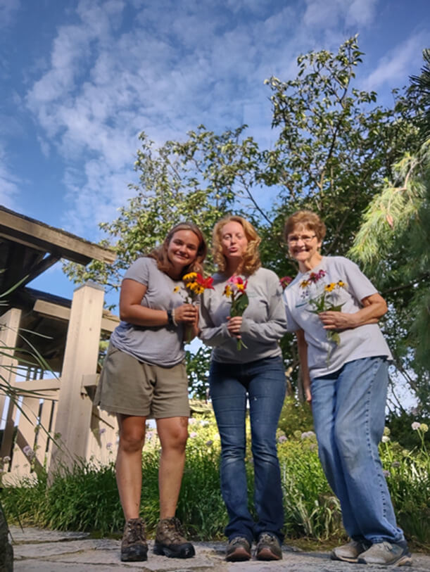 RBG staff & volunteers pose while holding flowers